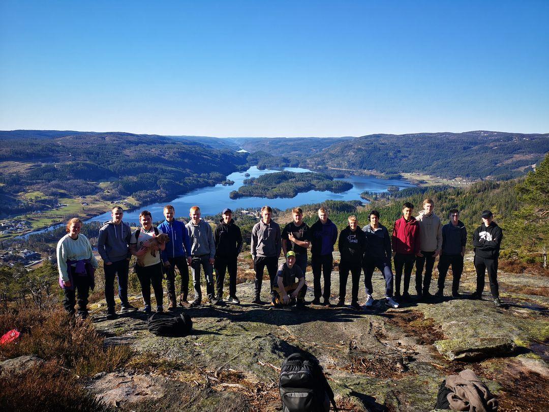En gruppe elever står på toppen av et fjell med utsikt utover Øydnavannet og dalen sørover. foto - Klikk for stort bilde